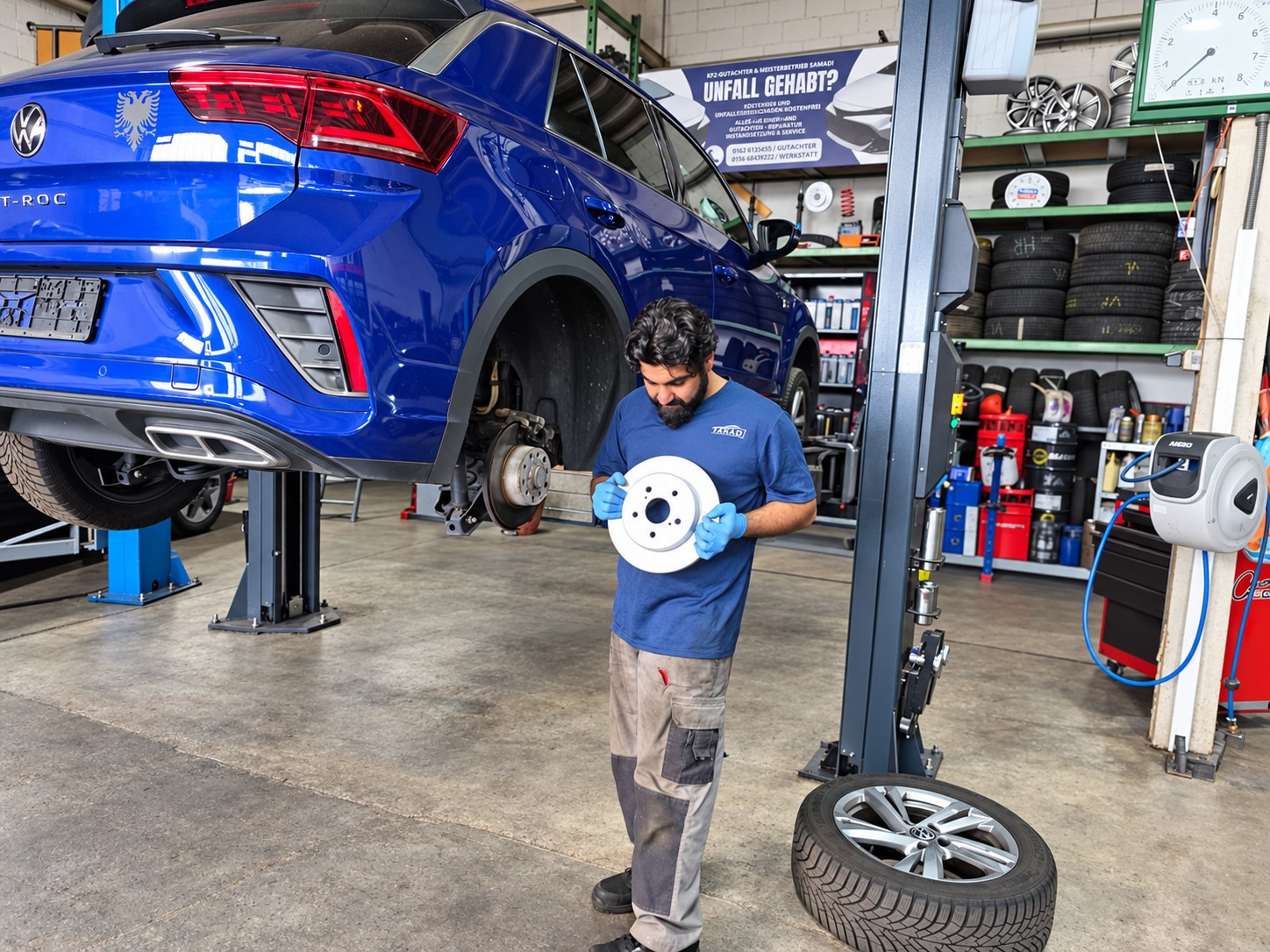Mechaniker von M&S Autoprofi in Hofheim mit neuer Bremsscheibe an einem Fahrzeug auf der Hebebühne